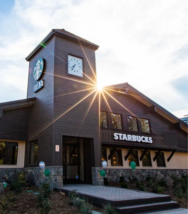 Photo of Starbucks coffee shop with sun setting in the background