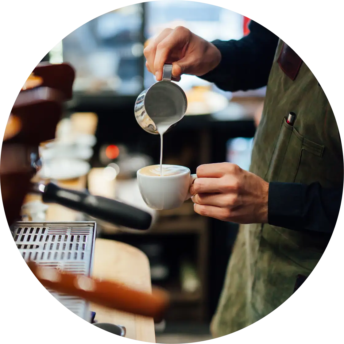 Photo of a barista pouring cream into a coffee drink